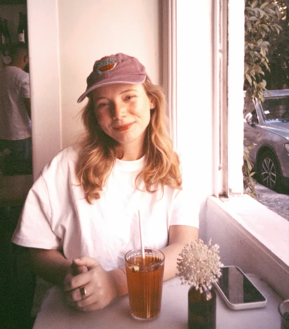 Portrait of Xenia smiling at a café table